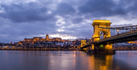 Budapest, Hungary - Beautiful illuminated Szechenyi Chain Bridge over River Danube with Buda Castle Royal Palace at blue hour