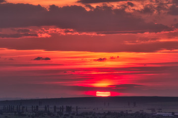 Beautiful rural landscape with a big red setting sun over the fields, Dobrogea, Romania