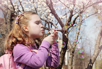 Cute little girl with soap bubbles.