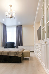 Спальня в светлых тонах с темной кроватью и синими шторами