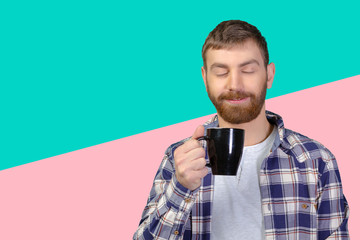 Young man holding warm cup of tea/coffee