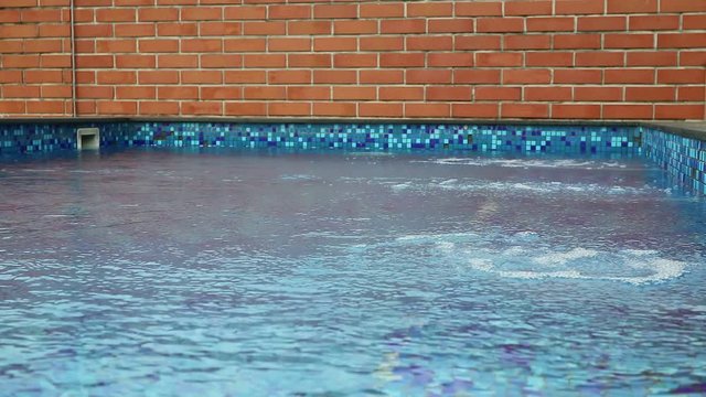 water has move by wind in swimming pool brick wall