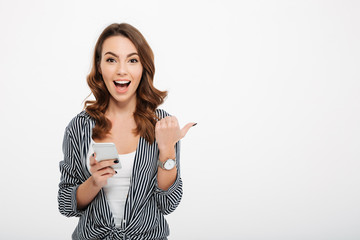 Portrait of a cheerful casual girl holding mobile phone