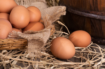 Brown Eggs on a Straw Covered Surface and in a Basket