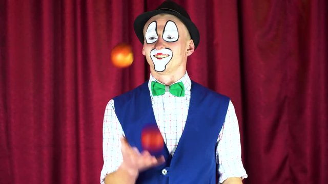 Funny clown juggles