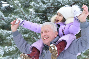 senior man and girl standing outdoors