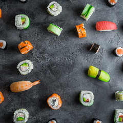 Pattern of sushi rolls on a dark background. Japanese food frame. Flat lay.