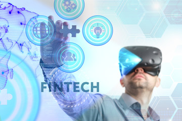 Business, Technology, Internet and network concept. Young businessman working in virtual reality glasses sees the inscription: Fintech