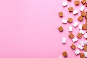 White and brown cane sugar cubes pile on a pink background. Copy space for text