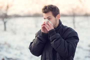 Handsome man blows his nose