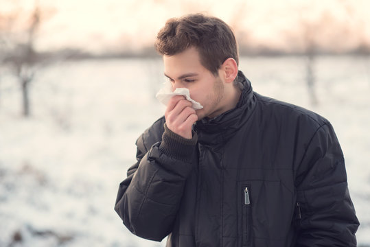 Handsome man blows his nose