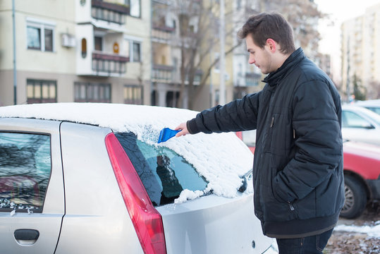 Scraping Snow And Ice From The Car Windscreen