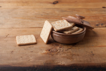 Homemade crispy crackers in a rustic wooden bowl, diet snack