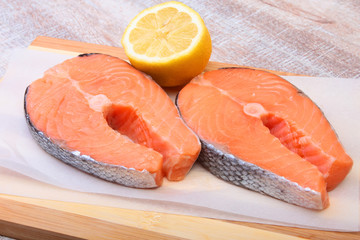 fresh raw salmon with spices and lemon on wooden cutting board. ready for cookin