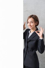 スーツ姿で案内する若い女性（コピースペース）