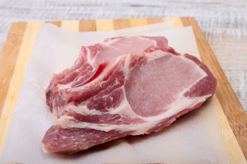Raw pork chops, spices on cutting board. Ready for cooking.