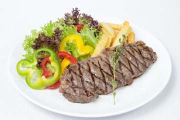 Striploin Steak served with fresh salad on white background