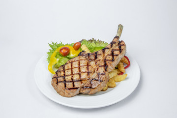 Pork Chop Steak served with fresh salad and french fried on white background