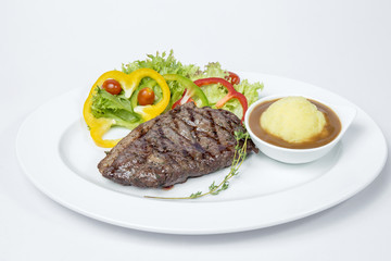 Sirloin Steak served with fresh salad and mashed potato on white background