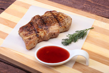grilled pork chop with Cranberry sauce on plate on wooden board