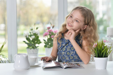 little girl reading magazine