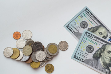 American dollar banknotes and different coins on a white background with copy space for text