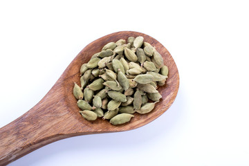whole cardamom seeds  on wooden spoon isolated on white background