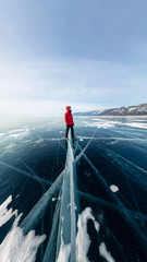 Panorama man stand on cracks on blue ice of Lake Baikal from Olkhon © Baikal360