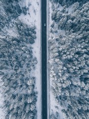 Obraz premium Country road going through the beautiful snow covered landscapes. Aerial view.