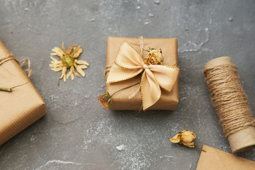 Fototapeta na wymiar Wrapped brown present box with dry flowers on vintage background
