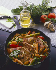 Ossobuco mit Gemüse in einer Schmorpfanne.Küchenatmosphäre