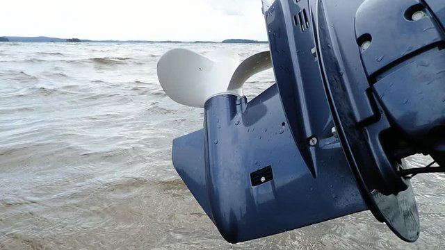 Outboard motor propeller lifted up from water