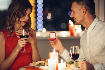 Pretty woman shocked about her man giving her an engagement ring in red box