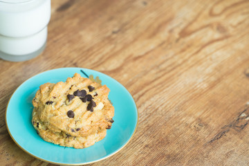 Chocolate chip cookies and glass of milk on old wooden table with place for text.freshly baked.