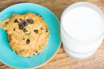 Chocolate chip cookies and glass of milk on old wooden table with place for text.freshly baked.