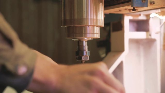 CNC machine. Replacement of the drill in the spindle with the wrench.