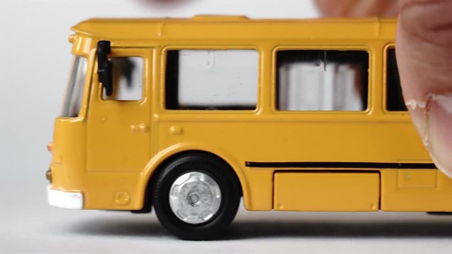 Male hand moving a toy bus