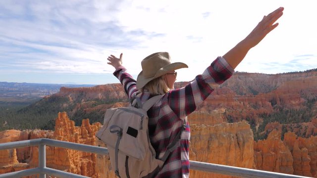 Woman Raised Hands Upwards While Standing On Observation Deck Overlooking Canyon