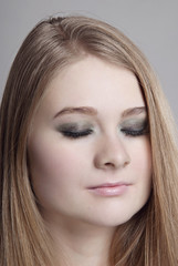 Fototapeta premium Makeup Smokey eyes for closed eyes girls blonde with clean skin closeup on gray background