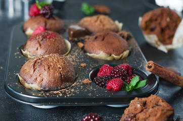 Chocolate homemade muffins with rapsberry on black background