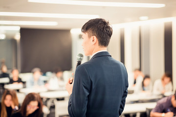 Businessman  giving a talk on corporate Business Conference. Audience at the conference hall. Business and Entrepreneurship event.