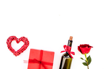 Present for Valentine day in red colors. Wine, rose, heart sign, gift box on white background top view copy space