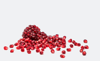 pomegranate with scattered grain on white background.