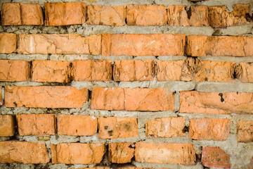Red old worn brick wall texture background. Vintage effect. Background. Old brick wall in the background. Old brick close-up with plaster. Grunge Brick Wall With Broken Plaster Texture. 