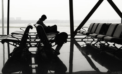 lonely passenger sitting wating at the airport in silhouette style - 189643471