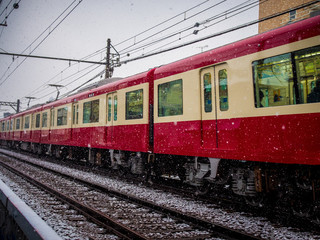 Fototapeta na wymiar 降り始めた雪の中を走る電車
