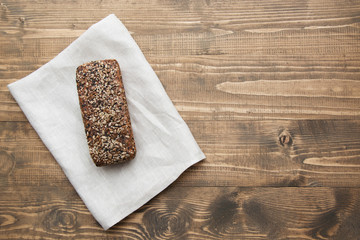 Fitness bread. A loaf of fresh rustic whole meal rye bread, sliced on a wooden board, rural food background. Top view. Copy space.