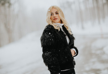 Fototapeta na wymiar Blonde woman outside in snow winter coat