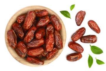 dry dates with green leaves in wooden bowl isolated on white background. Top view. Flat lay pattern