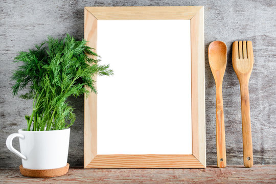An empty wooden frame and kitchen accessories on a gray wall.